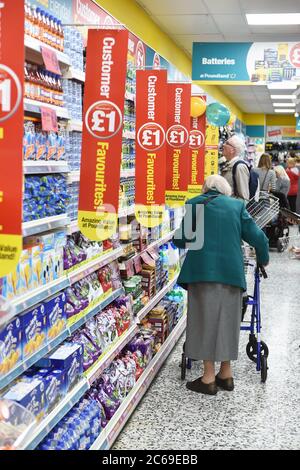 Eine ältere Frau kauft in Poundland mit ihrem zimmer Frame UK Stockfoto