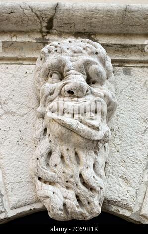 Teufelskopfrelief an der Fassade eines mittelalterlichen Hauses, Venedig, Italien. Stockfoto