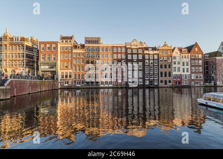 AMSTERDAM, NIEDERLANDE - 16. FEBRUAR 2016: Alte Gebäude am Damrak in Amsterdam tagsüber. Menschen können gesehen werden. Stockfoto