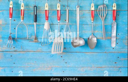 Vintage Küchengeräte an blauer rustikaler Wand, kostenloser Kopierplatz Stockfoto