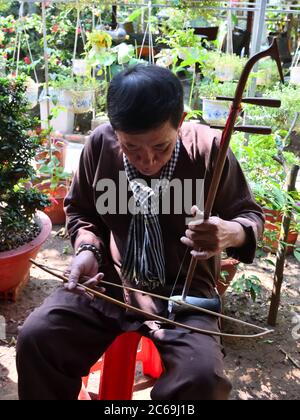 Ein Vietnamese spielt einen Dan Nhi (Dan Co) ein zweisaitiges Musikinstrument in der Thoi Son Commune, My Tho, Provinz Tien Giang, Vietnam Stockfoto