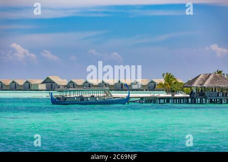 Maledivische Wasserbungalows. Luxus Reise Hintergrund, exotische über Wasser Villen, Holzboot Dhoni. Reiseziel für den Sommer Stockfoto