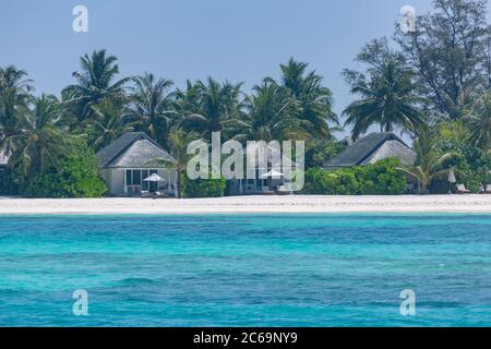 Luxuriöse Strandlandschaft mit Strandvillen oder Bungalows mit Palmen über weißem Sand und blauem Himmel. Sommer Reise und Urlaub Blick, Inseln Strand Stockfoto