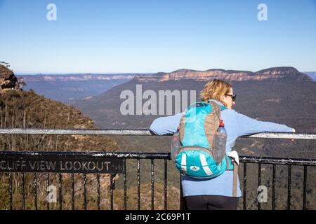 Blue Mountains Nationalpark Dame Frau Wanderer Modell freigegeben Ansichten Jamison Tal und Mt Solitary von Klippe Blick Aussichtspunkt, NSW, Australien Wintertag Stockfoto