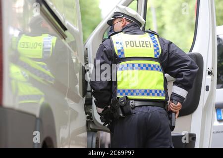 24. April 2020, Hamburg: Ein Polizist ist bei einer Polizeikontrolle in der Max-Brauer-Allee im Einsatz. Er hält seine Hand an seiner Dienstwaffe. Die Hamburger Polizei hat die Fahrer im Landkreis Altona auf die Einhaltung des Dieselfahrverbots überprüft. Auf fast 600 Metern der Max-Brauer-Allee gibt es ein Fahrverbot für ältere Diesel- und Lkw. Verstöße werden mit Geldbußen belegt. Foto: Bodo Marks/dpa Stockfoto