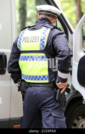 24. April 2020, Hamburg: Ein Polizist ist bei einer Polizeikontrolle in der Max-Brauer-Allee im Einsatz. Er hält seine Hand an seiner Dienstwaffe. Die Hamburger Polizei hat die Fahrer im Landkreis Altona auf die Einhaltung des Dieselfahrverbots überprüft. Auf fast 600 Metern der Max-Brauer-Allee gibt es ein Fahrverbot für ältere Diesel- und Lkw. Verstöße werden mit Geldbußen belegt. Foto: Bodo Marks/dpa Stockfoto