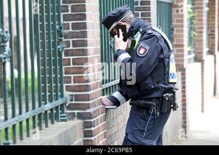 24. April 2020, Hamburg: Ein Polizist ist bei einer Polizeikontrolle in der Max-Brauer-Allee im Einsatz und prüft die Papiere eines Autofahrers. Die Hamburger Polizei hat die Fahrer im Landkreis Altona auf Einhaltung des Diesel-Fahrverbots überprüft. Auf fast 600 Metern der Max-Brauer-Allee gibt es ein Fahrverbot für ältere Diesel- und Lkw. Verstöße werden mit Geldbußen belegt. Foto: Bodo Marks/dpa Stockfoto