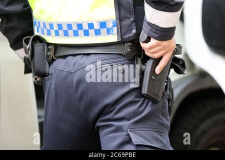 24. April 2020, Hamburg: Ein Polizist ist bei einer Polizeikontrolle in der Max-Brauer-Allee im Einsatz. Er hält seine Hand an seiner Dienstwaffe. Die Hamburger Polizei hat die Fahrer im Landkreis Altona auf die Einhaltung des Dieselfahrverbots überprüft. Auf fast 600 Metern der Max-Brauer-Allee gibt es ein Fahrverbot für ältere Diesel- und Lkw. Verstöße werden mit Geldbußen belegt. Foto: Bodo Marks/dpa Stockfoto