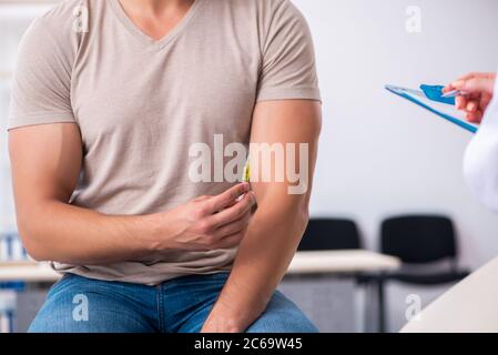 Männlicher Diabetiker, der einen jungen Arzt besucht Stockfoto