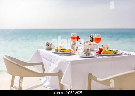 Romantisches Abendessen am Strand. Weingläser neben einem wunderschönen Tisch, Luxus-Resort-Hotel mit Blick auf den Strand Stockfoto