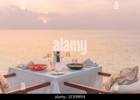 Romantisches Abendessen am Strand. Weingläser neben einem wunderschönen Tisch, Luxus-Resort-Hotel mit Blick auf den Strand Stockfoto