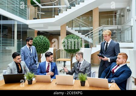 Führungskonzept. Junge enthusiastische Führungskräfte aus zwei verschiedenen Ländern trafen sich, um über neues Projekt zu diskutieren Stockfoto