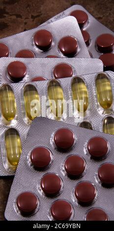 Pillen und farbige Kapseln sind in der Verpackung. Farbige Tabletten und Kapseln von oben. Stockfoto