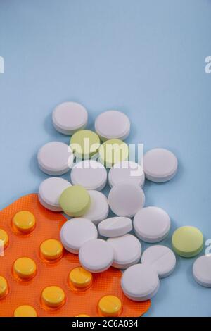 Farbige Tabletten aus der Verpackung. Farbige Pillen mit einem einfachen Hintergrund und verschiedenen Farben zusammen. Stockfoto