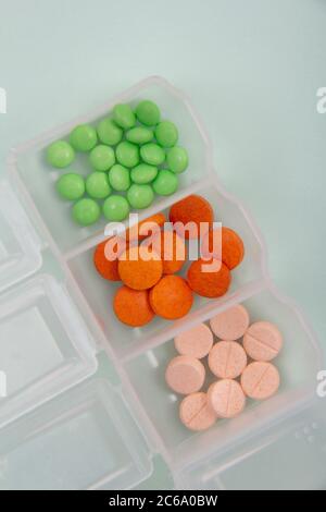 Farbige Tabletten aus der Verpackung. Farbige Pillen mit einem einfachen Hintergrund und verschiedenen Farben zusammen. Stockfoto