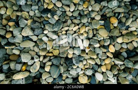 Kleine Stein Textur Hintergrund. Kiesel am Strand. Flussstein für Gartendekoration. Glatte Textur grau Rock mit natürlichen Muster. Draufsicht Stockfoto