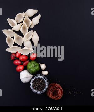 Bunte und bunte Pasta in großer Zahl und in verschiedenen Farben zusammen mit verschiedenen Früchten und Gemüse. Stockfoto