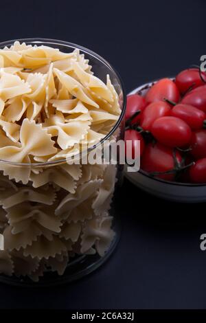 Bunte und bunte Pasta in großer Zahl und in verschiedenen Farben zusammen mit verschiedenen Früchten und Gemüse. Stockfoto