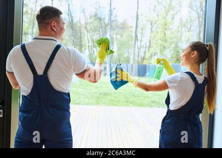 Rückansicht auf Team von Reinigungskräften machen Frühjahrsputz im neuen Haus. Zwei Hausmeister in Uniform Stockfoto