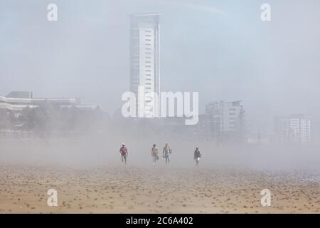 Im Bild: Eine gruppe von vier Personen geht in der niedrigen Wolke in Swansea Bay, Wales, Großbritannien. Mittwoch 20 Mai 2020 Re: Eine niedrige Wolke hat das Meer und die Ba bedeckt Stockfoto