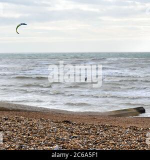 In der Nähe des Strandes reitet ein Kite Surfer Wellen Stockfoto