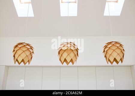 Bild von trendigen drei Kronleuchter im europäischen Stil aus hellem Holz, weiß innen. In Form von Kegel. Stockfoto