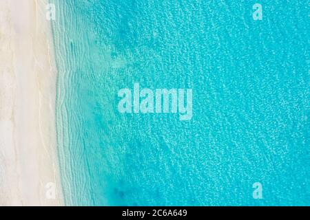 Top-down Luftaufnahme eines weißen Sandstrands an den Ufern eines wunderschönen türkisfarbenen Meeres. Meeresstrand, schöne Landschaft, Reisen und Urlaub. Stockfoto