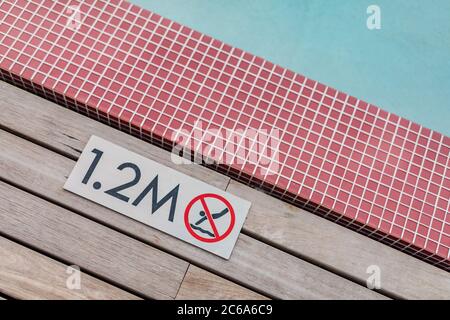 Schwimmbadrand mit 'No Diving 1.2 M.' Warnschild. Sommerurlaub Stockfoto