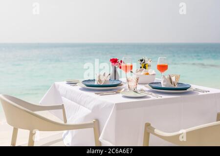 Luxus Frühstück Essen auf weißem Tisch, mit schönen tropischen Meerblick Hintergrund, morgens Zeit Sommerurlaub und romantischen Urlaub, Luxus-Lifestyle Stockfoto