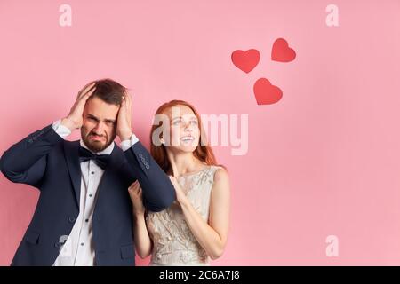 Porträt von traurig verärgert Mann hält Kopf und Frau lächeln und träumen. Stockfoto