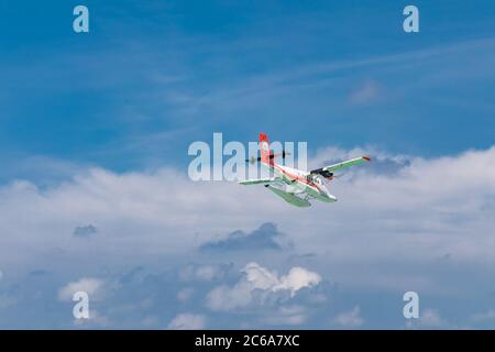 Male, Maldives - 12/17/2017: Das Wasserflugzeug der Fluggesellschaft Trans Maldivian Airways fliegt in blauem Himmel über Male. Luxusreisen, exotischer Urlaub Transport Stockfoto