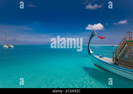 Inspirierendes Stranddesign der Malediven. Malediven traditionelles Boot Dhoni und perfektes blaues Meer mit Lagune. Luxuriöses tropisches Paradies. Sommerurlaub Stockfoto