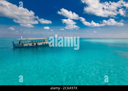 Inspirierendes Stranddesign der Malediven. Malediven traditionelles Boot Dhoni und perfektes blaues Meer mit Lagune. Luxuriöses tropisches Paradies. Sommerurlaub Stockfoto