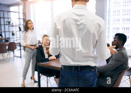 Blick auf den Rücken des Mannes in weißem Hemd mit internationalen Gruppe von Geschäftsleuten sprechen Stockfoto