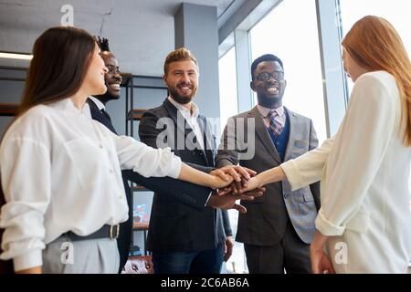 Multiethnische, interrassische Freundschaft, Partnerschaftskonzept. Internationale Gruppe von Geschäftsleuten hat sich im Büro zusammengetan Stockfoto