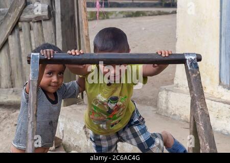 Ein paar Kinder, die zum Khasi-Stamm aus Meghalaya, Indien, gehören und mit einem Holzkarren vor ihrem Haus spielen. Stockfoto