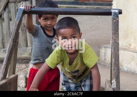 Ein paar Kinder, die zum Khasi-Stamm aus Meghalaya, Indien, gehören und mit einem Holzkarren vor ihrem Haus spielen. Stockfoto