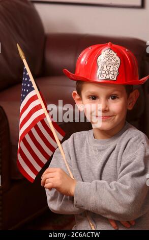 Austin, Texas, USA, 31. Januar 2002: Robin David Daemmrich, 5 Jahre, posiert mit einem Feuerwehrhelm und einer amerikanischen Flagge während des Spiels. Er sagt, er will ein tapferer Feuerwehrmann sein, wenn er groß ist. ©Bob Daemmrich Stockfoto