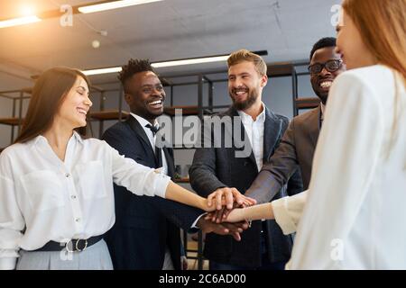 Freundliche Kollegen arbeiten zusammen als Team im Büro, lächeln. Business People Konzept Stockfoto
