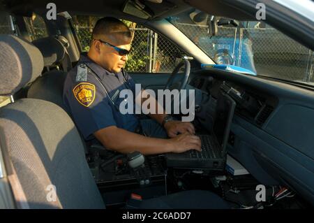 San Antonio, Texas, USA, 7.-8. August 2003: Polizeibeamte im Süden von San Antonio. Officer Ben Sigala berichtet über den Panasonic Toughbook-Computer seines Polizeiautos. Es hat Internet, GPS, alle anderen notwendigen Informationssysteme. ©Bob Daemmrich Stockfoto