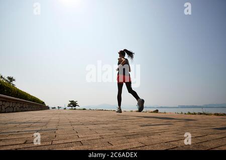 Junge asiatische Erwachsene Frau Joggen im Freien Stockfoto