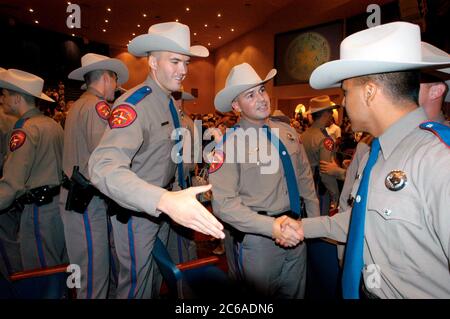 Austin, Texas, USA, 5. September 2003: Mitglieder der neuen Kadettenklasse des Ministeriums für öffentliche Sicherheit (DPS) gratulieren einander, nachdem sie ihre Provisionen in einer Zeremonie erhalten haben, bei der 160 Soldaten zur texanischen Staatspolizei hinzukamen. Die DPS-Offiziere sind die sichtbarsten der texanischen Verbrechensbekämpfer und patrouillieren die tausende Kilometer langen Highways des Bundesstaats. ©Bob Daemmrich Stockfoto