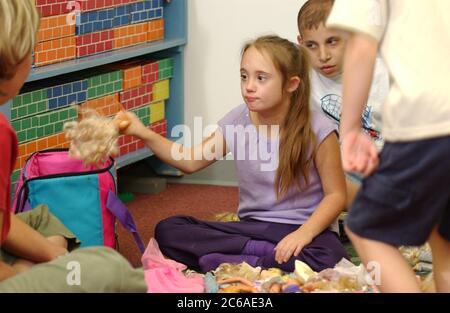 Gun Barrel City, Texas, USA, 9. September 2003: Ein siebenjähriges Mädchen mit Down-Syndrom spielt gerne mit Puppen und küsst sie, bevor sie in ihr Klassenzimmer in der zweiten Klasse eingesperrt werden. MODELLVERSION SP62. ©Bob Daemmrich Stockfoto