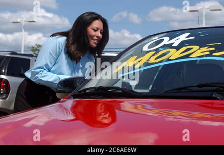 Austin, Texas 20. August 2003: Hispanische Frau (28) kauft ein Auto in einem Chevrolet GM-Händler auf der "Motormeile" von Süd-Austin. Angesichts der wirtschaftlichen Lage in der Flaute ist es für Verkäufer schwierig, in diesem Sommer Käufer in neue Fahrzeuge zu locken. MODELL VERÖFFENTLICHT SP-40 hispanische weiblich. ©Bob Daemmrich Stockfoto