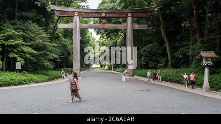 Touristen und Besucher gehen am riesigen hölzernen Torii-Tor im Meji Jingu-Schrein, Tokio, japan vorbei Stockfoto