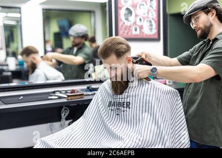 Die Hände der jungen Friseur Haarschnitt zu attraktiven Mann im barbershop Stockfoto