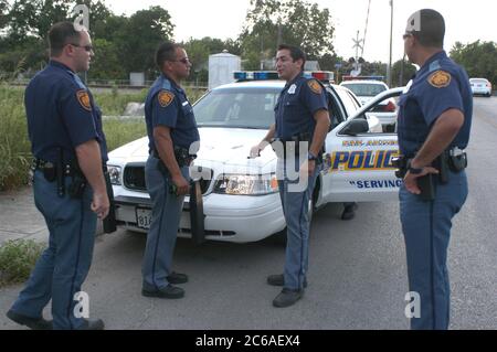 San Antonio, Texas 7.-8. August 2003: Polizisten sprechen, nachdem sie Verdächtige bei einem Raub auf einem überwucherten Feld festgenommen haben. Keine Releases. ©Bob Daemmrich Stockfoto