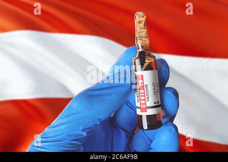 Österreich Flagge mit Coronavirus Covid-19 Konzept. Arzt mit blauen Schutz medizinische Handschuhe hält eine Impfstoffflasche. Coronavirus covid 19 Impfstoff resear Stockfoto