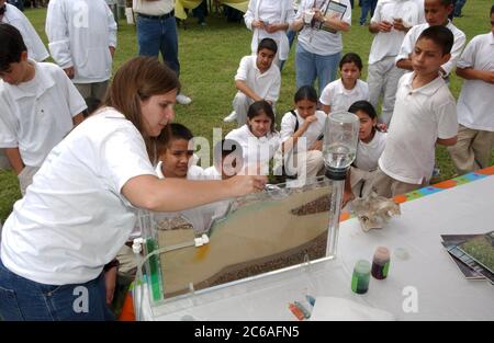 Austin Texas, USA, April 2004: Schüler der 6. Und 7. Klasse erfahren auf der von der City of Austin gesponserten Outdoor-Veranstaltung Blue Thumb mehr über Wasser- und Abwasserprobleme. Eine Lehrerin zeigt den Schülern einen Querschnitt eines Grundwasserleiters. Daemmrich Stockfoto