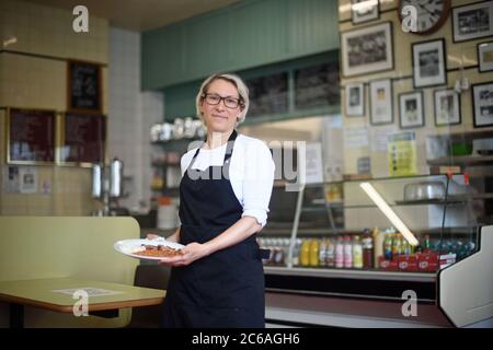 Claudia Perotti, Inhaberin des Regency Cafe in Westminster, London, als der Kanzler seinen Antrag ankündigt, die Menschen zum Essen zu ermutigen, mit einer Mehrwertsteuersabszung von 20% auf 5% im Gastgewerbe und einem Rabatt "Eat Out to Help Out". Gäste, die im August in teilnehmenden Restaurants in ganz Großbritannien essen, können jeden Montag, Dienstag und Mittwoch zum halben Preis speisen. Stockfoto